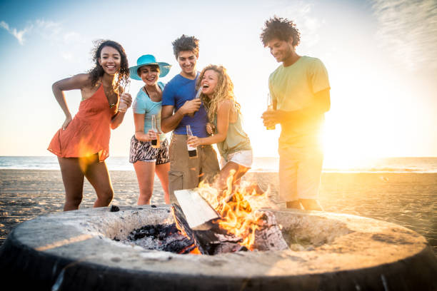 friends partying on the beach - bonfire beach fire barbecue imagens e fotografias de stock