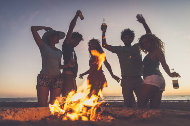 friends partying on the beach - bonfire beach fire barbecue imagens e fotografias de stock