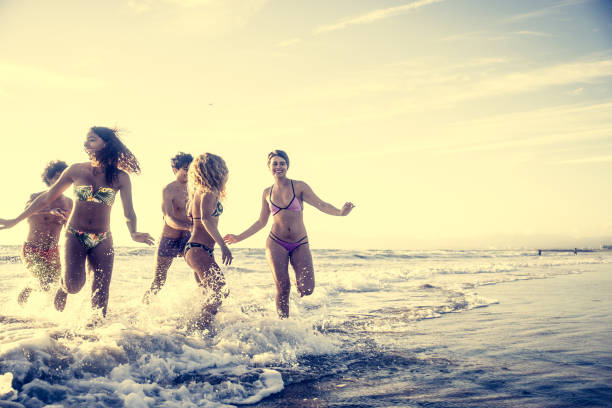 istock Friends running on the beach 1384629205