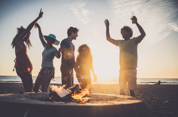 friends partying on the beach - bonfire beach fire barbecue imagens e fotografias de stock