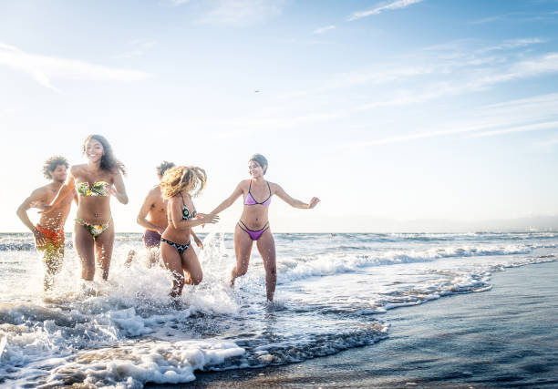 istock Friends running on the beach 1384629409