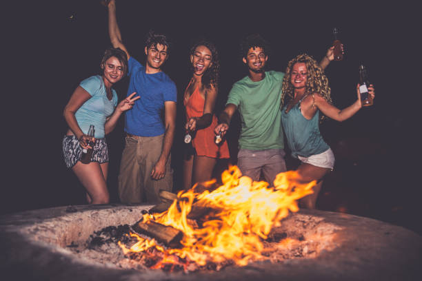 friends partying on the beach - bonfire beach fire barbecue imagens e fotografias de stock