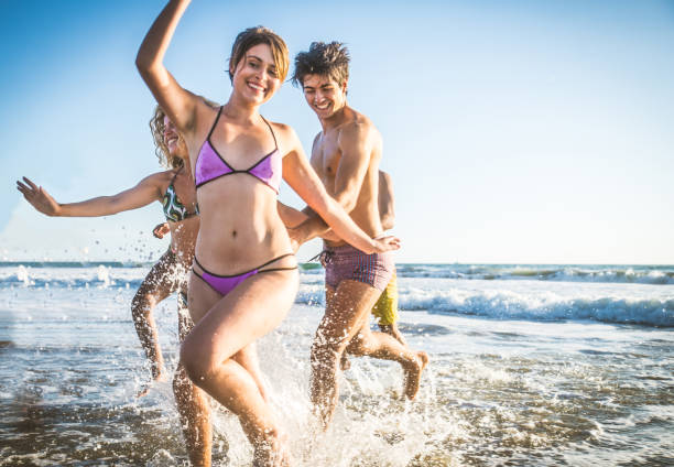 istock Friends running on the beach 1384630162
