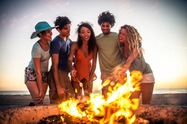 friends partying on the beach - bonfire beach fire barbecue imagens e fotografias de stock