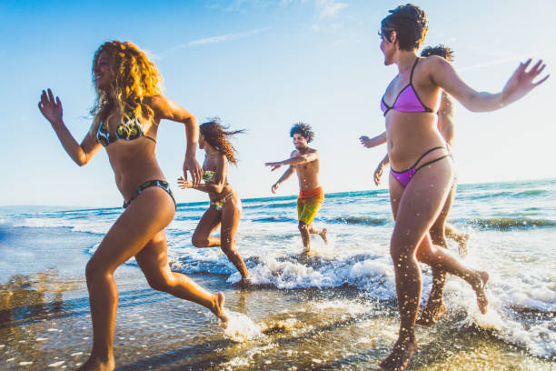 istock Friends running on the beach 1384630254