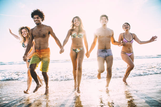 istock Friends running on the beach 1384630338