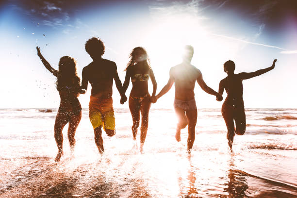 istock Friends running on the beach 1384630472