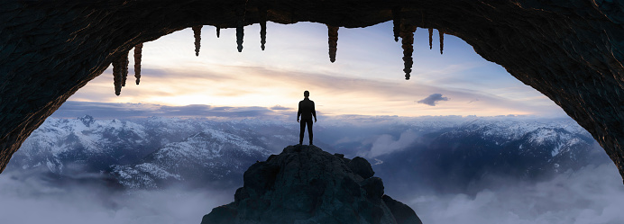 Dramatic Adventurous Scene with Man standing inside an Alien like Rocky Cave Landcspae. 3d Rendering. Sunset Sky. Aerial Mountain Image from British Columbia, Canada. Adventure Concept Artwork