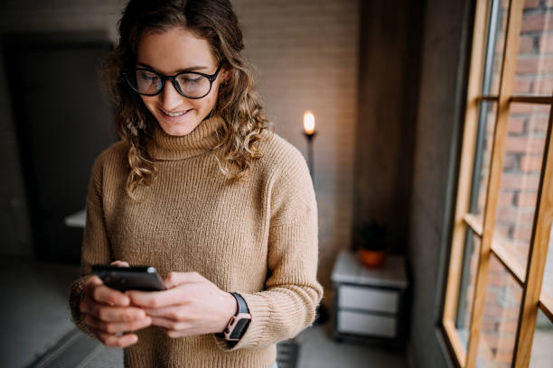 istock Beautiful woman texting a friend 1384637576
