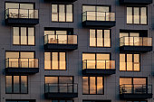 istock The evening sun is reflected in the modern glass facade with balconies 1384642884