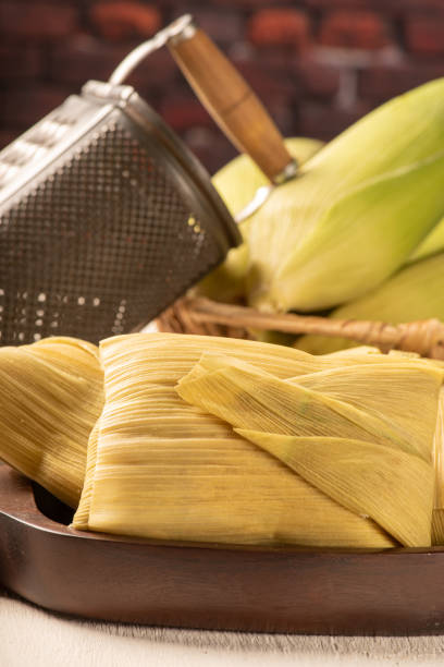 istock Brazilian corn snack pamonha and green corn arranged on a white rustic wooden table, selective focus. 1384645796