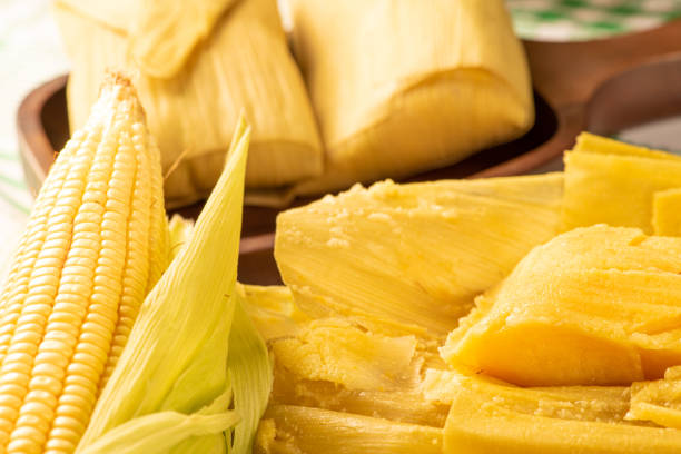 istock Brazilian corn snack pamonha and cornflower arranged on a table with green and white tablecloth, selective focus. 1384645852