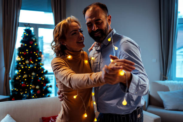 istock Handsome man dancing with his mature wife at home 1384648595
