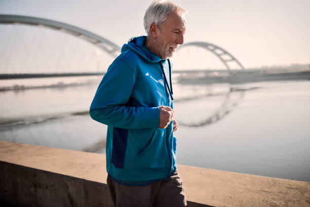 istock Senior in a sportswear running along river 1384648711
