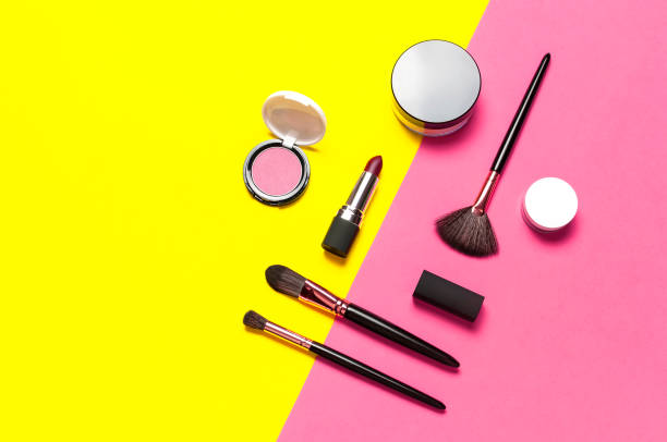 Professional makeup brushes, powder, eyeshadow, blush, lipstick on yellow pink background flat lay top view copy space. Beauty product women's accessory fashion. Different brushes. Cosmetic makeup Set. pinceles de maquillaje profesionales, polvo, sombra de ojos, rubor, lápiz labial sobre fondo amarillo rosa plano lay top view copy space. producto de belleza moda de accesorios para mujer. diferentes pinceles. set de maquillaje cosmético