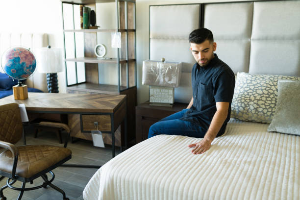 istock Young man choosing a new mattress and bed covers 1384649541