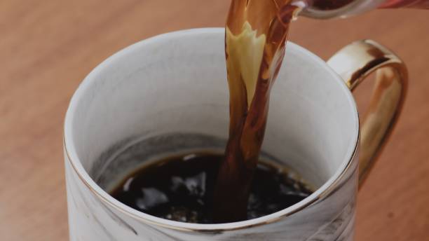 istock Black specialty coffee being served in mug on wooden table 1384649977