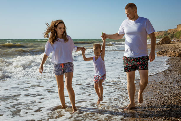 istock Happy family walking by the sea 1384653064