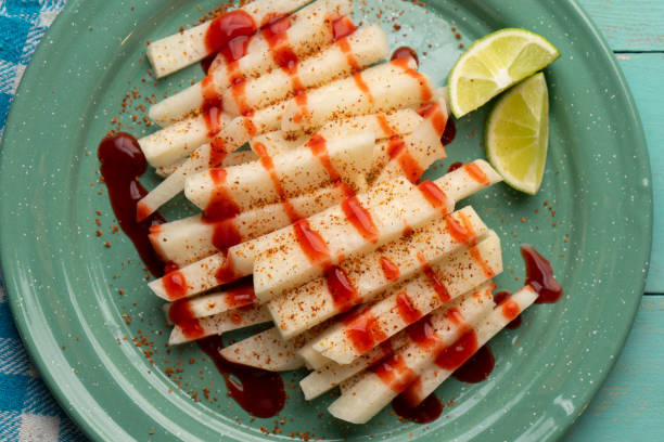 Mexican yam bean also called Jicama with chili powder and chamoy sauce Cutted mexican yam bean also called Jicama with chili powder and chamoy sauce pachyrhizus erosus stock pictures, royalty-free photos & images