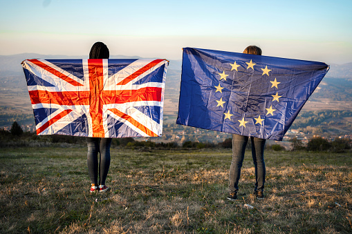 Two women standing on the hill holding EU and UK flag