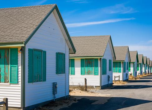 A row of identical beachside cottages  on the road leading to Provincetown, Massachusetts on a mild mid March afternoon wait for summer visitors.