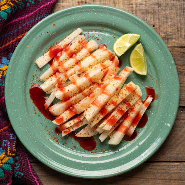 Mexican yam bean also called Jicama with chili powder and chamoy sauce Cutted mexican yam bean also called Jicama with chili powder and chamoy sauce pachyrhizus erosus stock pictures, royalty-free photos & images