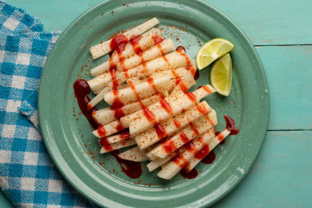 Mexican yam bean also called Jicama with chili powder and chamoy sauce Cutted mexican yam bean also called Jicama with chili powder and chamoy sauce pachyrhizus erosus stock pictures, royalty-free photos & images