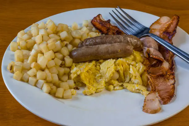 sausage and bacon with scrambled eggs and a side of hash browns