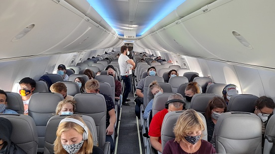 Scene Of People Wearing Non Medical Face Mask Due To COVID-19 Pandemic, Standing, Sitting Down Inside Passengers Airplane In Ottawa Ontario Canada