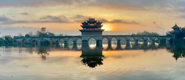 The silhouette of traditional style bridge against sunrise, Yunnan province, China stock photo