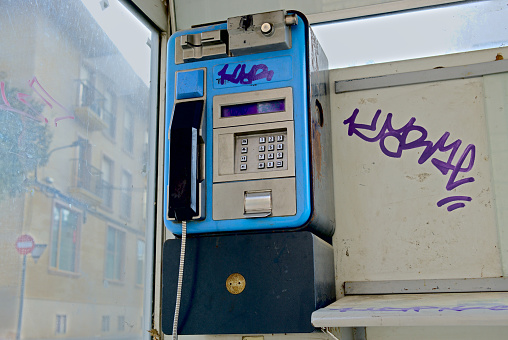 February 2022. Ibi, Alicante, Spain - Deteriorated and dirty telephone booth at the street. All phone booths are removed from the whole country, obsolete technology, non profitable business. High quality photo
