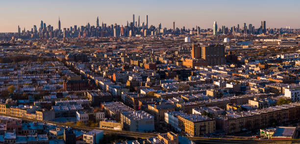 manhattan midtown skyline comprende l'empire state building, hudson yards e altri grattacieli iconici. vista sul quartiere residenziale di bushwick, brooklyn, al tramonto.   panorama cucito extra-large ad alta risoluzione. - dramatic sky manhattan moody sky new york city foto e immagini stock