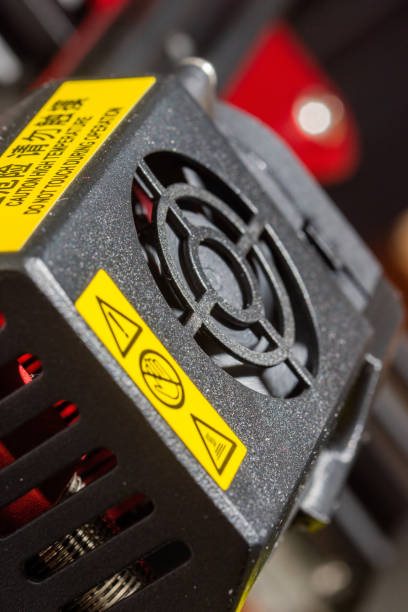 istock Close-up of 3D printer printerhead with hotend and fan. Modern 3D printer detail. Vertical photo. 1384672113
