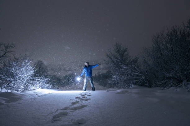 istock Man in forest at night showing the road. 1384673046