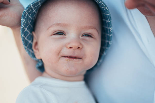 portrait of an adorable toothless baby boy smiling with his mouth full of food - healthy eating profile tropical fruit fruit imagens e fotografias de stock