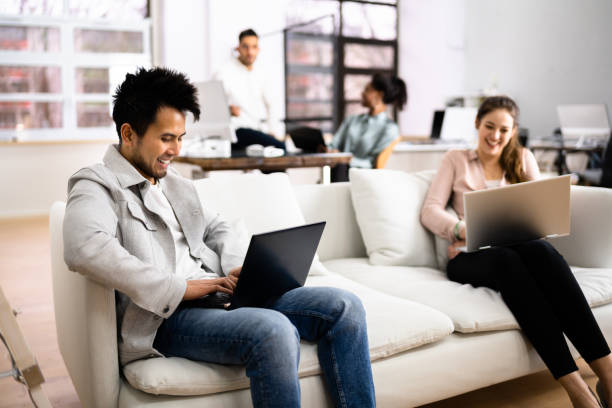 Young Diverse People Working Young Diverse People Working In Coliving Space office buddies stock pictures, royalty-free photos & images