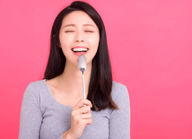 dama feliz y hambrienta sostener cuchara de metal en la boca deseo cena pensar en comida sabrosa - women spoon tasting elegance fotografías e imágenes de stock