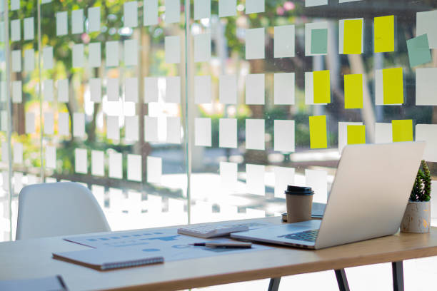 istock Laptop on the business desk with graphs, documents, coffee mugs, calculators in the office. 1384692196