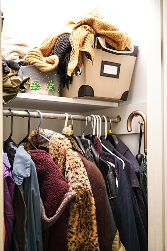 A crowded unorganized coat closet.