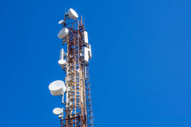 istock Telecommunications tower with cellular antenna on blue sky background. Look up. 1384704509