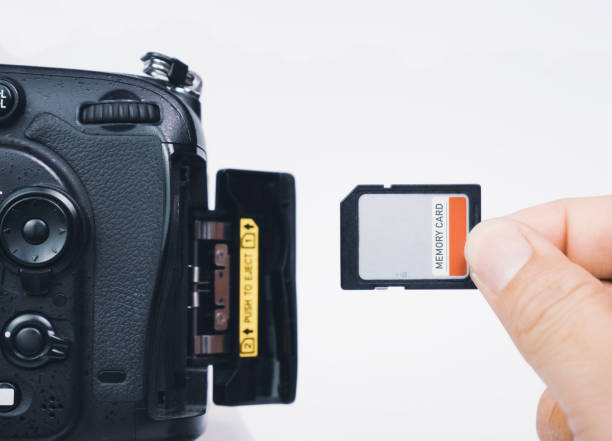 istock Photographer hand insert memory SD card to memory slot 1384707971
