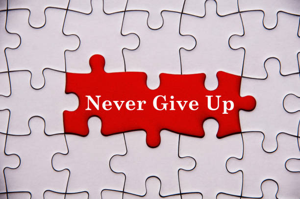 istock Never give up text on missing jigsaw puzzle. Motivational and inspirational concept 1384714622