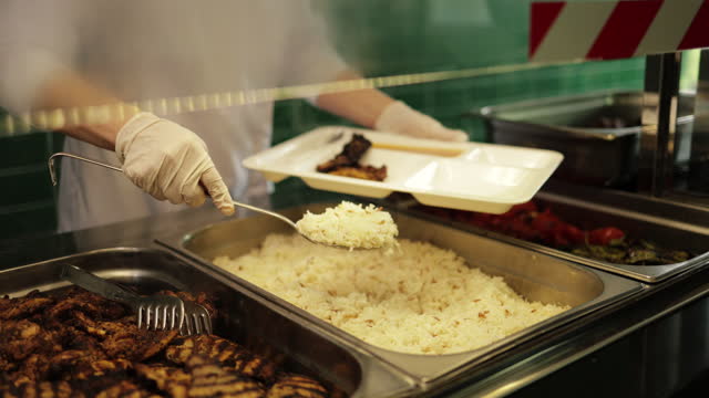 The cook serves the rice and chicken she cooks in a canteen to the employees at the factory, Food from catering dinner table, Buffet salad bar,