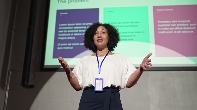 Black female professional giving presentation in a conference.