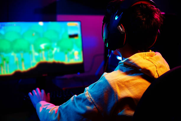 istock Gamer play computer game, use rgb neon colored keyboard 1384738781