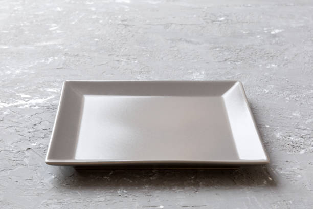istock Perspective view of empty square plate on cement background. Empty space for your design 1384747879
