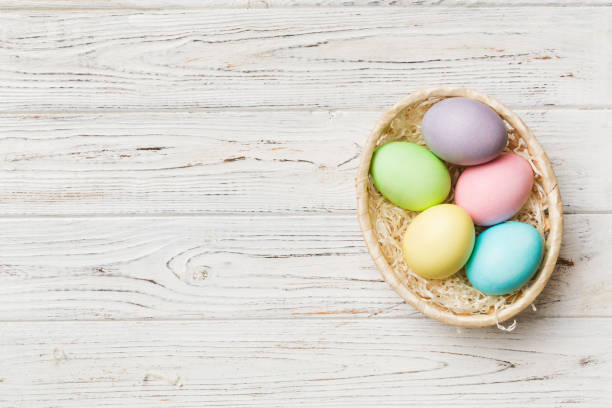 istock Multi colors Easter eggs in the woven basket on colored background . Pastel color Easter eggs. holiday concept with copy space 1384747881