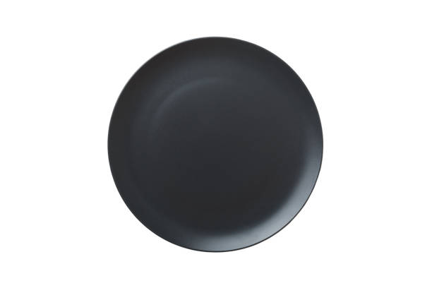 istock Black ceramic round plate isolated over white background. Top view 1384747970