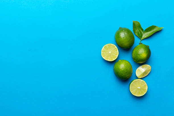 istock Lime fruits with green leaf and cut in half slice isolated on white background. Top view. Flat lay with copy space 1384747975