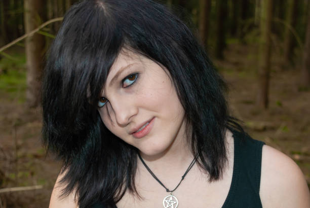 Punk emo girl, young adult with black hair and eyeliner, close-up Punk emo girl, young adult with black hair and eyeliner, looking at camera, smiling, outdoors, horizontal, close-up black hair emo girl stock pictures, royalty-free photos & images
